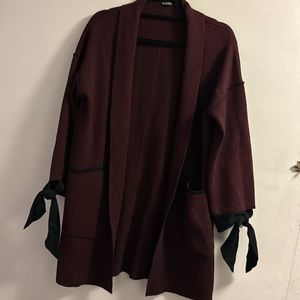Maroon oversized cardigan with black bows on sleeves